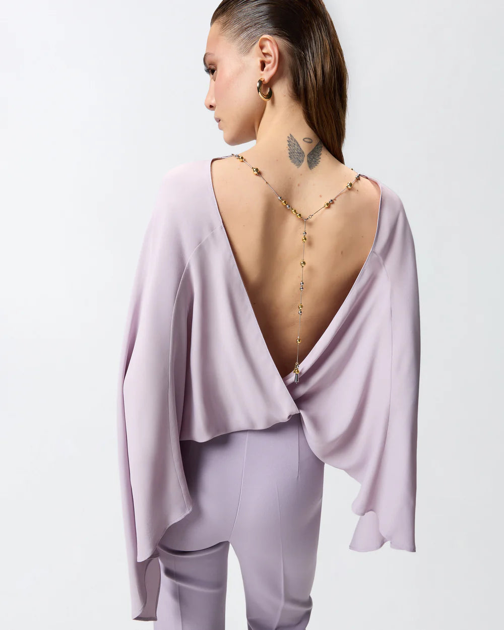Lilac jumpsuit with open back and jeweled necklace
