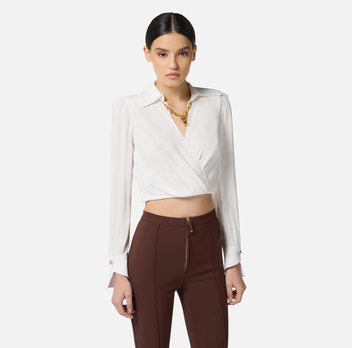 White cropped blouse with long sleeves and gold chain detail