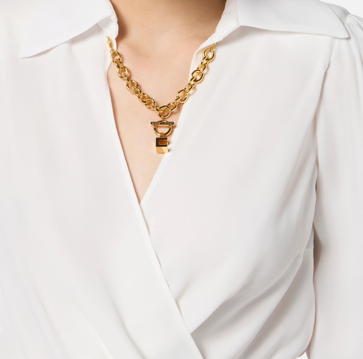 White cropped blouse with long sleeves and gold chain detail